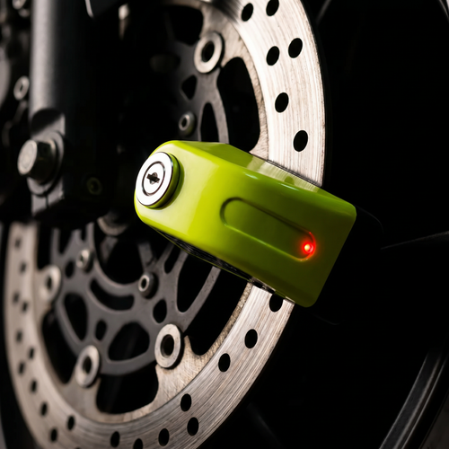 DiscGuard clamped on motorcycle brake disc at night